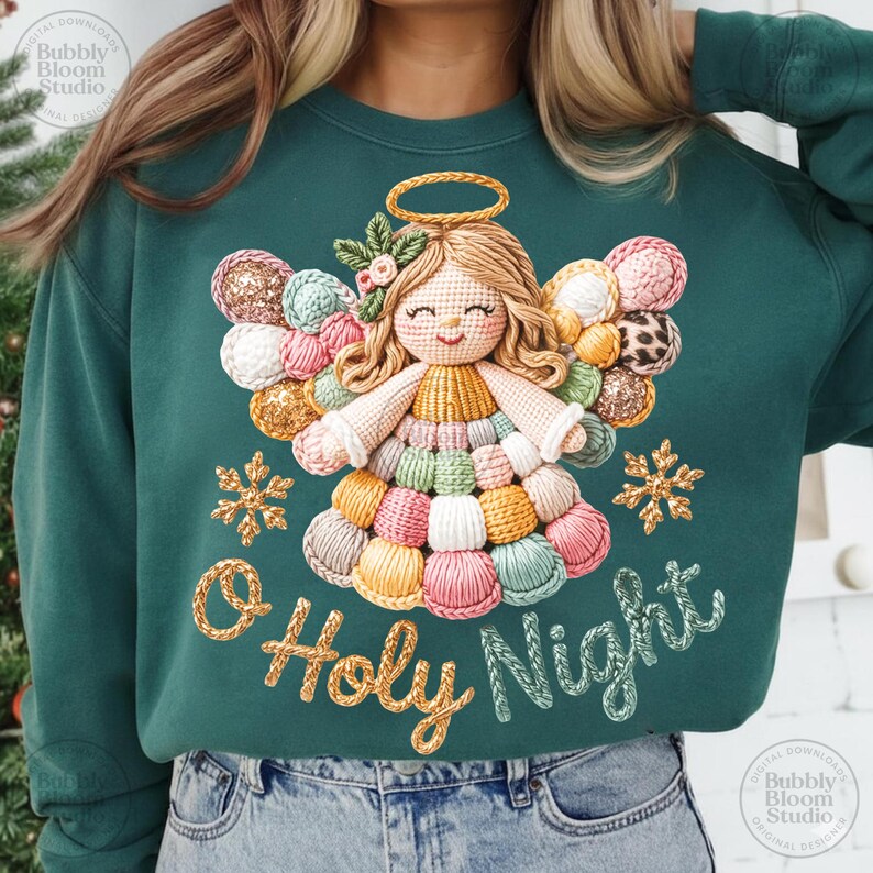 May include: A teal green sweatshirt featuring a crocheted angel design with a halo and colorful wings. The angel is surrounded by snowflakes and the words "O Holy Night" in a script font. The design is a digital download.