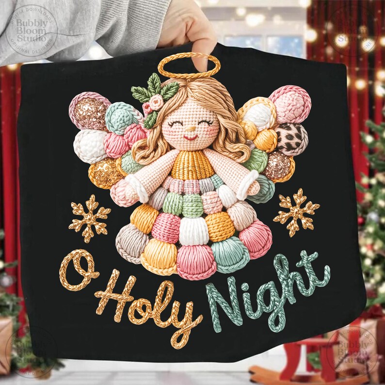 May include: Black fabric Christmas decoration featuring a crocheted angel with a gold halo and colorful yarn wings and dress. The words "O Holy Night" are embroidered in gold and teal. Two gold snowflakes are also embroidered on the fabric.