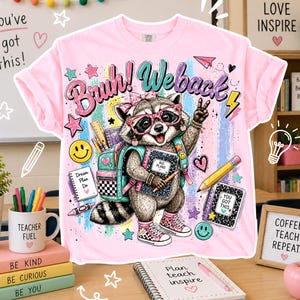 Puede incluir: Camiseta rosa con un mapache con gafas y una mochila, sosteniendo un cuaderno. La camiseta tiene el texto "Bruh! We back" y gr&aacute;ficos escolares. Las palabras "You've got this!" tambi&eacute;n son visibles.