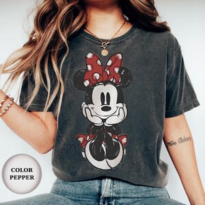 Puede incluir: Una taza de cer&aacute;mica blanca con asa negra y el texto "But First, Coffee" en negrita negra. La taza se encuentra sobre un fondo borroso, sugiriendo un ambiente acogedor.