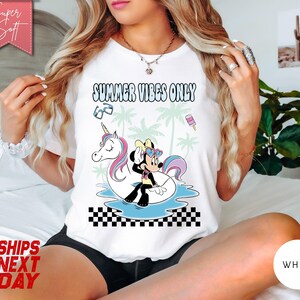 May include: A white t-shirt featuring the text SUMMER VIBES ONLY in a wavy font. The graphic shows a cartoon mouse wearing heart-shaped sunglasses sitting on a unicorn pool float in blue water, surrounded by palm trees, sunglasses, and a popsicle.