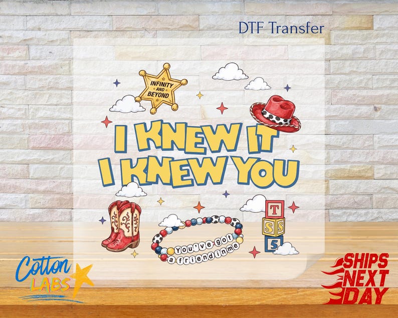 May include: A DTF transfer sheet featuring a graphic design with the text I KNEW IT I KNEW YOU. Elements include a yellow sheriff star with INFINITY AND BEYOND, a red cowboy hat, red and white boots, a beaded bracelet with YOU'VE GOT A FRIEND IN ME, and alphabet blocks.