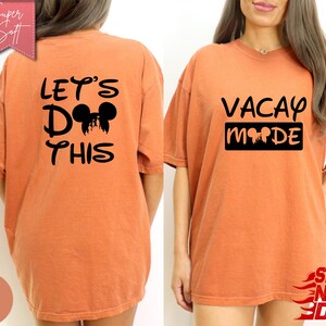 May include: Burnt orange t-shirts with black graphic text and Mickey Mouse silhouettes. One shirt reads "LET'S DO THIS" on the back. The other shirt says "VACAY MODE" on the front. The shirts are labeled "Super Soft".