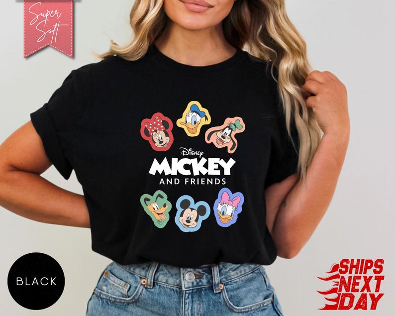 May include: Black t-shirt featuring the text "Disney MICKEY AND FRIENDS" with cartoon character graphics. The shirt includes images of Mickey Mouse, Minnie Mouse, Donald Duck, Daisy Duck, Goofy, and Pluto. The shirt is labeled "Super Soft".