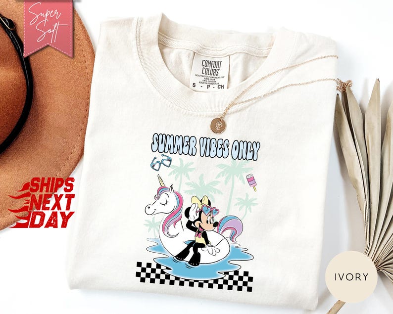 May include: An ivory t-shirt featuring a graphic of a cartoon mouse wearing heart-shaped sunglasses while sitting on a unicorn pool float in water. The text reads SUMMER VIBES ONLY, accompanied by palm trees, sunglasses, and a popsicle graphic.