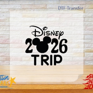 May include: Black graphic DTF transfer with the word "Disney" above the number "26" with a Mickey Mouse head silhouette, and the word "TRIP" below. The text "DTF Transfer" is at the top, and "Cotton Labs" is at the bottom left.