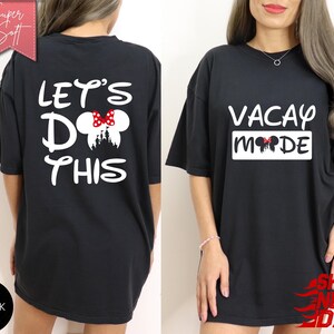 May include: Black t-shirts with white text and a Minnie Mouse design. One shirt says "LET'S DO THIS" with a castle silhouette and a bow. The other says "VACAY MODE" with a bow. The shirts are labeled "Super Soft".