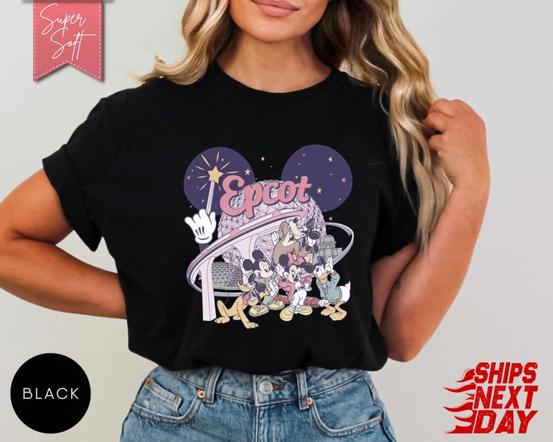 May include: Black t-shirt featuring a colorful graphic of Disney characters and the word "Epcot" in a stylized font. The design includes Mickey Mouse, Donald Duck, and other characters. The shirt has a round neckline and short sleeves.