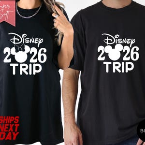 May include: Black t-shirts with a white Disney design. The design includes the Disney logo, the numbers "2026", and the word "TRIP". One shirt has a Minnie Mouse bow. The shirts are labeled "Super Soft" and "Ships Next Day".