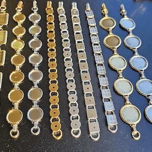 May include: An assortment of gold and silver-toned bracelets. The bracelets feature various designs, including square, round, and patterned links. Each bracelet has a clasp for secure wear. The collection offers a range of styles for accessorizing.