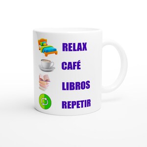 Puede incluir: Taza de cerámica blanca con las palabras "RELAX CAFÉ LIBROS REPETIR" en morado. La taza presenta ilustraciones de una cama, una taza de café, libros y un símbolo de reciclaje.
