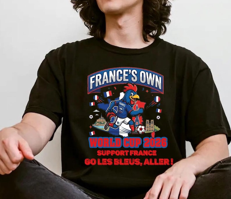 A person wearing a black t-shirt with a graphic design featuring a rooster and the text "FRANCE'S OWN WORLD CUP 2026 SUPPORT FRANCE GO LES BLUES, ALLER!"