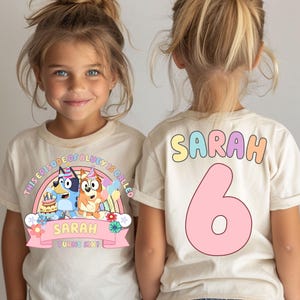 two young girls wearing white t-shirts with a birthday-themed design.