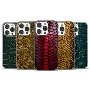 Könnte beinhalten: Fünf Smartphone-Hüllen in einer Reihe, jede mit einem eigenen strukturierten Muster. Die Designs umfassen dunkelgrüne Krokodilhaut, goldbraune Alligatorhaut, ein tiefrotes Schlangenschuppenmuster, gelbe Schlangenhaut und blaugrüne Krokodilhaut.