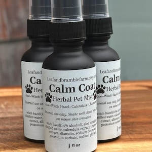 May include: Three black spray bottles of "Calm Coat Herbal Pet Mist" with white labels and black text. The labels include the product name, ingredients, and instructions. Each bottle is 1 fl oz.