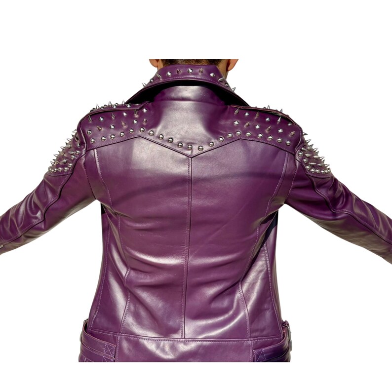 May include: A purple leather jacket with silver metal spikes on the shoulders and upper back. The jacket has a classic collar and a tailored fit. The back view shows the jacket's design and detailing.