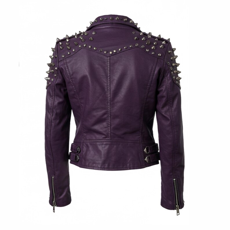 May include: A purple faux leather jacket with silver metal cone studs on the shoulders and collar. The back of the jacket features a vertical seam and two small buckles at the waist. The sleeves have zippers at the cuffs.
