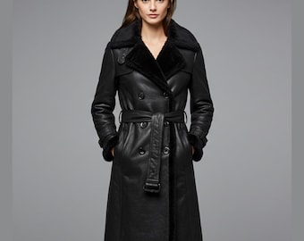 May include: A black leather trench coat with a double-breasted design. The coat features a belt at the waist, a shearling collar, and shearling trim on the cuffs and hem. The coat is knee-length.