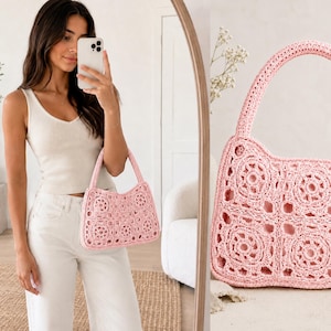 May include: A light pink crochet handbag with a rectangular shape and a handle. The bag features a floral pattern and is made of a soft, textured material. The bag is shown in a mirror.