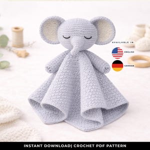 Può includere: Una coperta di sicurezza a forma di elefante all'uncinetto in grigio chiaro, con un viso sorridente, grandi orecchie e un corpo quadrato. L'immagine mostra anche scarpine per bambini, un anello di legno e il testo "INSTANT DOWNLOAD | CROCHET PDF PATTERN".