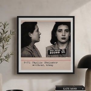 May include: Framed black and white mugshot print featuring a woman in a striped shirt and tweed jacket. The print includes the text "SAN DIEGO PD APR. 1944" and "20389". Below, it reads "N-271 Phyllis Stalnaker weedhead, tramp".