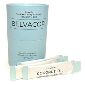 May include: A light blue cylindrical container with the brand name "BELVACOR" and text indicating "Organic Teeth Whitening Pulling Oil". Several travel-size sachets of spearmint coconut oil are in front of the container.