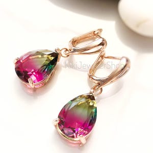 May include: A pair of rose gold earrings with teardrop-shaped, multi-colored gemstones. The gemstones transition from pink to green. The earrings have a lever back closure. The image is on a white background.