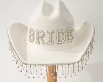 Chapéu de noiva estilo cowboy com franjas de strass e pérolas: Ideal para despedida de solteira com tema country e chá de panela.