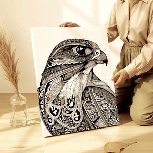 May include: Black and white artwork of a hawk's head, featuring intricate patterns and details. The bird's eye is large and detailed, with a sharp beak. The artwork is on a white canvas.