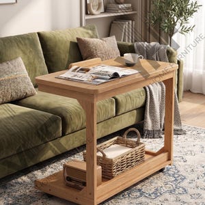 May include: A light oak wood side table with a magazine, mug, and woven basket. The table has a rectangular top and a lower shelf. The table is next to a green sofa with decorative pillows. The text "YO HOME FURNITURE" is visible.