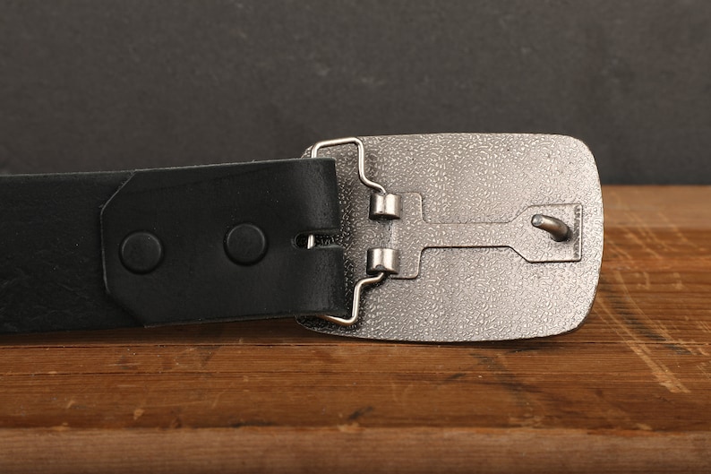 a black belt with a silver buckle on a wooden table