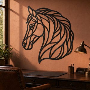 Könnte beinhalten: Schwarze Metall-Wandkunst mit einem Pferdekopf. Das Kunstwerk zeigt ein detailliertes, geometrisches Design eines Pferdekopfes und einer Mähne. Die Kunst ist an einer strukturierten, rotbraunen Wand angebracht. Ein Schreibtisch und eine Lampe sind im Vordergrund zu sehen.