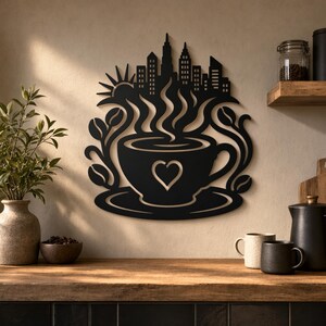 Può includere: Un'opera d'arte da parete in metallo nero raffigurante una tazza di caffè con un cuore intagliato, vapore che sale verso la sagoma di uno skyline cittadino e un sole. Il design è incorniciato da rami di chicchi di caffè su entrambi i lati.