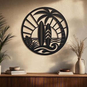 Pode incluir: Arte de parede em metal preto com um design circular com tema de praia. A obra de arte inclui duas pranchas de surf, uma palmeira e um sol se pondo sobre o oceano. O design é recortado, criando um efeito de silhueta.