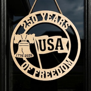 May include: A circular wooden sign with the text "250 YEARS OF FREEDOM" and a USA flag. The sign also features the Liberty Bell and the years 1776-2026. It is suspended by a rope.