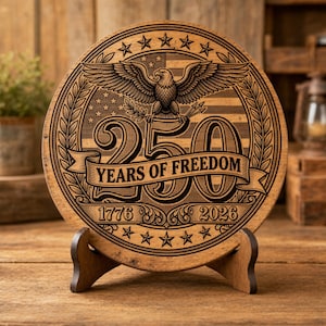 Könnte beinhalten: Runde Holzplakette mit eingraviertem Design, das einen Adler, Sterne und den Text "250 YEARS OF FREEDOM 1776-2026" zeigt. Die Plakette wird auf einem Holzständer präsentiert, mit patriotischem Thema.