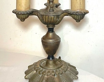 May include: A three-light antique brass table lamp with a decorative base and three frosted glass shades. The lamp has a finial on top and a base that resembles a turtle.