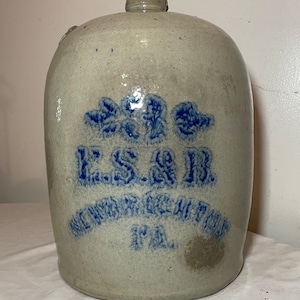 May include: A vintage stoneware crock with blue and white painted lettering that reads "ESAR,  SCHUYLKILL HAVEN, PA".