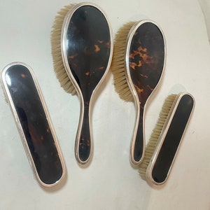 May include: Set of four tortoiseshell hairbrushes with silver trim. The brushes have natural bristles and are in excellent condition.