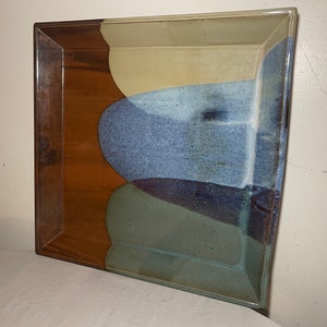 May include: Square ceramic serving tray with a brown, beige, blue, and green glaze. The glaze is applied in a layered pattern, creating a unique and artistic design.