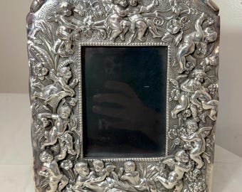 Marco de fotos antiguo de plata de ley 925 con figura de querubín putti y adornos.