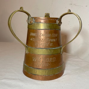 May include: A copper and brass trophy with two handles. The trophy is engraved with "Orange Camera Club 4th Prize Sprint Class B. Wm Lord 1906."