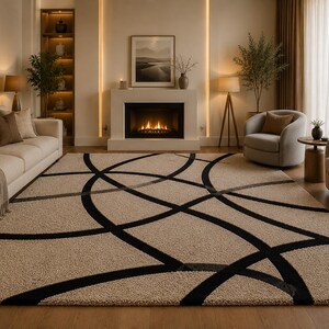 May include: A rectangular area rug featuring a textured beige pile with a bold, black geometric pattern consisting of intersecting curved lines and circular arcs that span across the entire surface of the floor covering in a living room.