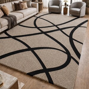 May include: A rectangular area rug featuring a textured beige pile with a bold, black geometric pattern of intersecting curved lines. The rug has a thick, shaggy surface texture and covers a large portion of the floor space in the room.