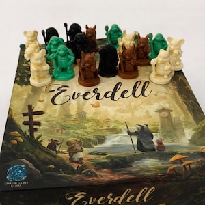 May include: The board game "Everdell" is shown with a variety of animal figurines in cream, green, brown, and black. The box has a detailed forest scene illustration and the game's title in a decorative script.