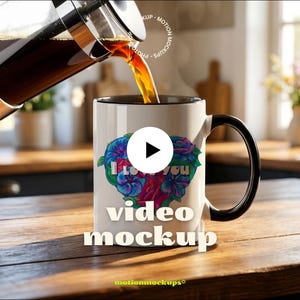 May include: A white coffee mug with a black handle and rim is being filled with coffee. The mug features a floral heart design with the words "I Love You" and "video mockup" printed on it. The mug sits on a wooden surface.