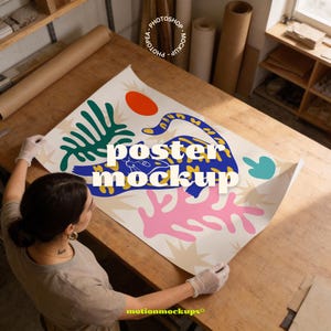 以下が含まれることがあります： ヒョウ、太陽、植物の形を特徴とする、カラフルな抽象的なデザインの大きなポスターモックアップ。「poster mockup」という文字が印刷されています。ポスターは木製のテーブルの上に置かれています。