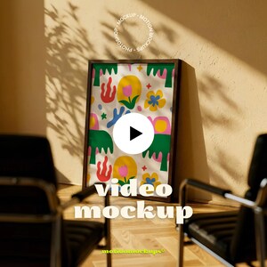 Puede incluir: Una impresión artística enmarcada con un colorido patrón floral con elementos amarillos, rosas y verdes. La impresión se muestra en una habitación con dos sillas negras y el texto "video mockup".