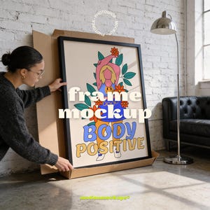 Op de afbeelding: Een ingelijste kunstdruk met de woorden "BODY POSITIVE" in een retro lettertype. Het kunstwerk toont een kleurrijke illustratie van een persoon met bloemen en bladeren. De lijst is zwart en de print zit in een kartonnen doos.