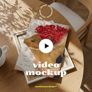 Puede incluir: Una impresión en lienzo con una ilustración en acuarela de un ramo de rosas rojas. La obra de arte está sostenida por una persona con un envoltorio de papel marrón. El texto "Let's fall in love" es visible. También se muestran las palabras "video mockup".